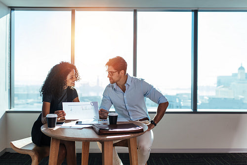 Young business investors discussing business matters in office.