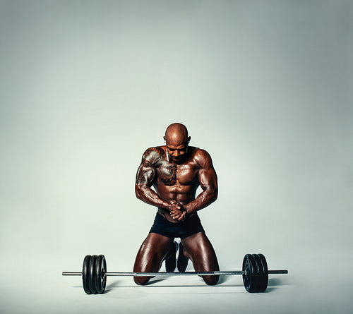 Muscular young man working out with heavy weights