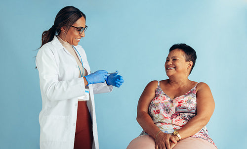 Doctor with senior woman smiling during vaccination