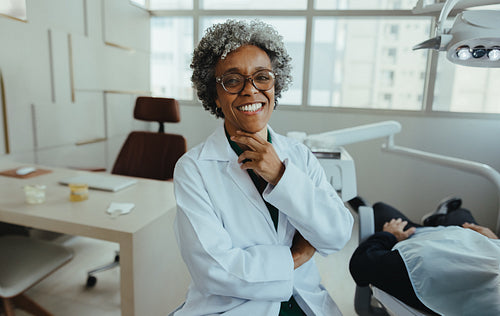 Female dentist smiling during consultation with patient in modern clinic