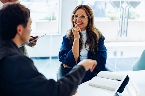 Businesswoman smiles as she participates in a business meeting