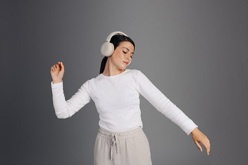 Young woman dancing and enjoying some music in a studio