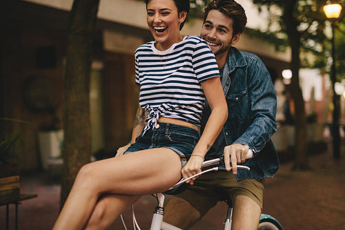 Couple having fun while riding bicycle