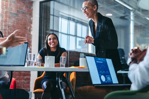 Young businesswoman receiving praise from her team in an office
