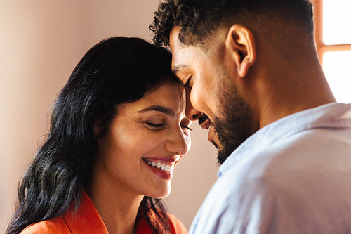 Joyful couple sharing an intimate moment in a warmly lit setting