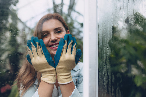 Happy female gardener in plant nursery