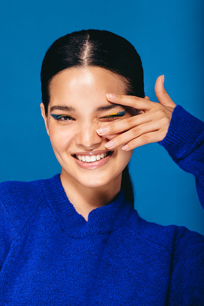 Express yourself with makeup: Woman with graphic eyeliner smiles and winks at the camera