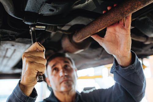 Auto mechanic repairing a car in service station