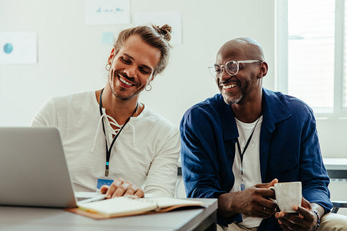 Young diverse coworkers discussing ideas and notes in a collaborative meeting