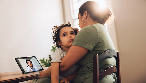 Mother and son having online medical consultation at home