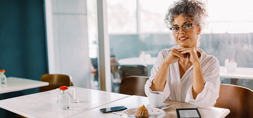 Cheerful businessswoman sitting in a cafe