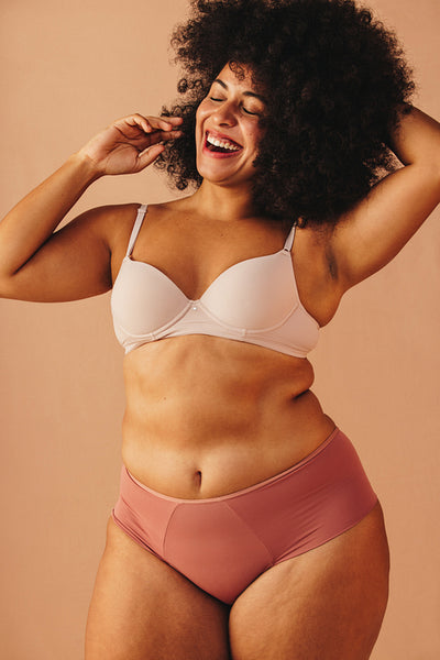 Beautiful plus size woman smiling happily in underwear
