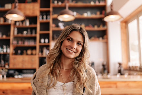 Beautiful young woman standing in a coffee shop