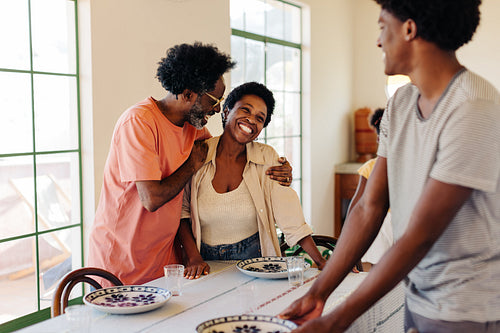 Brazilian family setting the table with plates for a breakfast meal