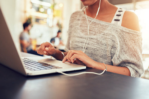 Young woman using laptop at coffee shop