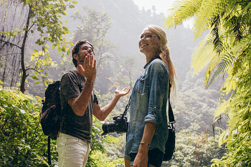 Tourist couple enjoying the rain in forest