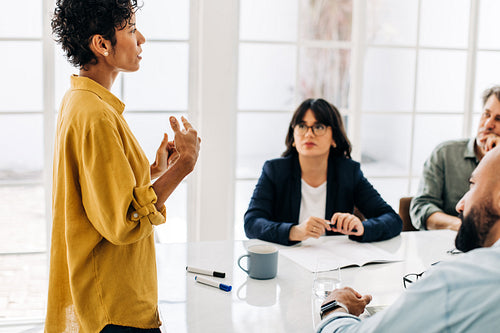 Business woman giving a speech in a team meeting