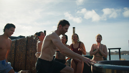 Friends cheering during outdoor cold plunge challenge and social wellness recovery session