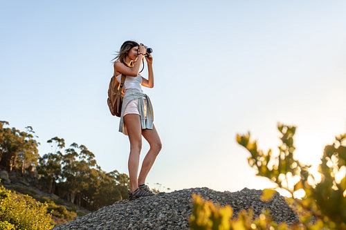 Hiker taking pictures with camera from the hill