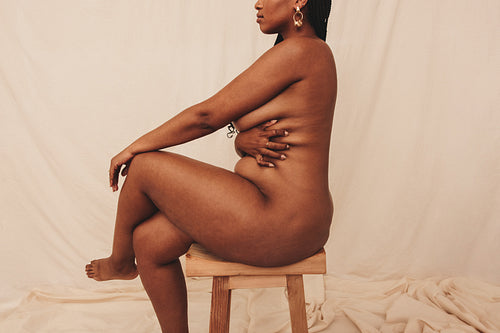 Young woman embracing her natural body in a studio