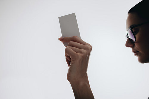 Woman holding a blank card in a minimalist and modern setting