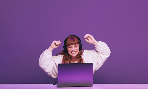 Female gamer celebrating winning an online video game in a studio