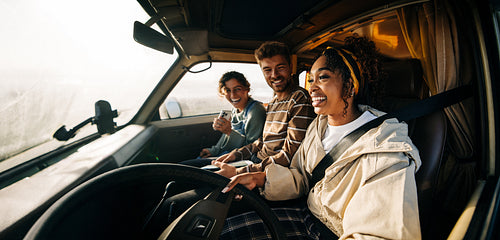 Three friends enjoy a road trip inside a van