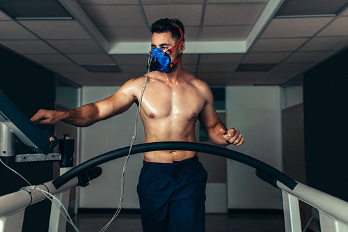 Professional athlete on treadmill monitoring his performance