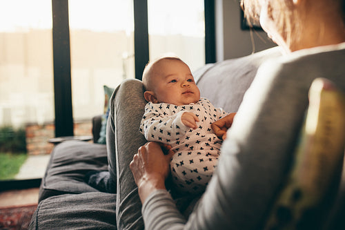 Woman sitting on couch with her baby