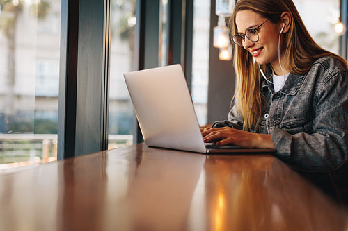 Woman using laptop at a cafe
