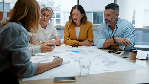 Design project in a creative office: Professional architects discussing drawings in a team meeting