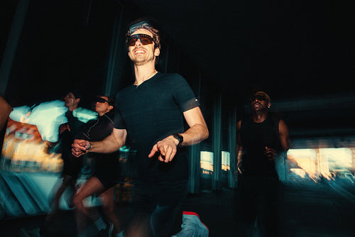 Male runner leads night run club session with energetic outdoor pace