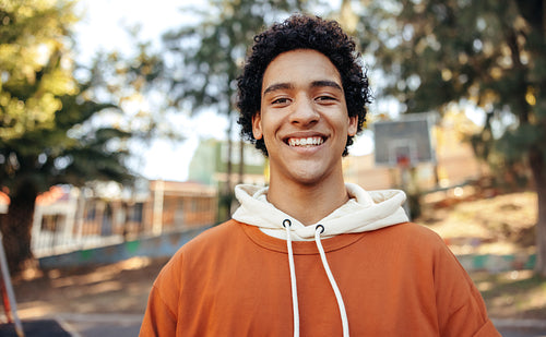 Happy male youngster smiling at the camera outdoors