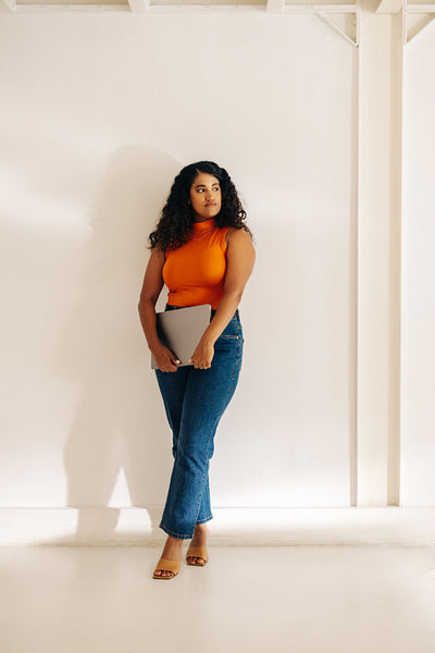 Pensive businesswoman standing against an office wall
