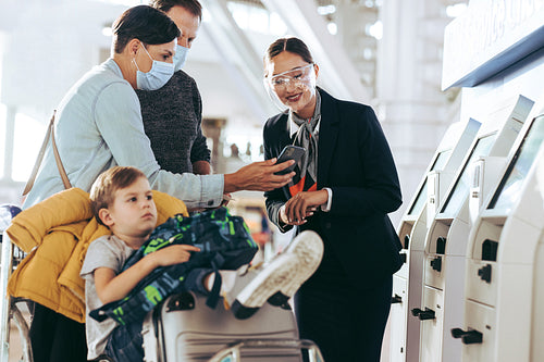 Ground staff assisting family at airport
