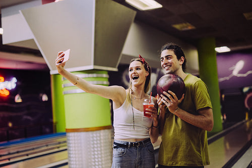 Couple taking selfie at bowling alley