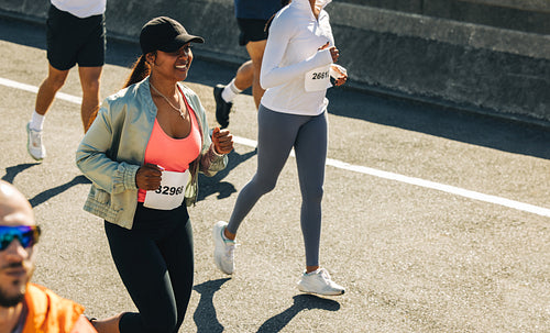 Confident smiling female runner in a competitive race