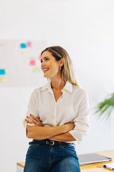 Happy young businesswoman sitting in a creative office