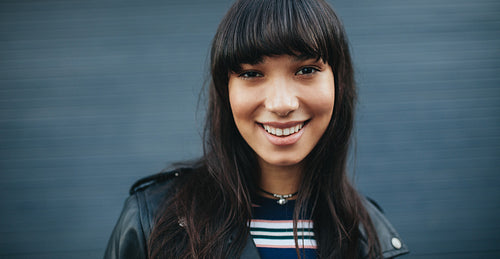 Beautiful female model standing against gray background