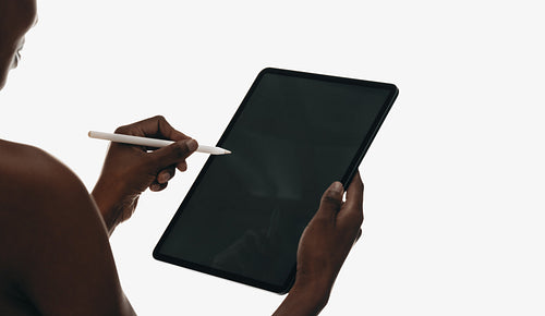 Person drawing on a digital tablet with a stylus pen