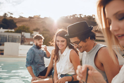 Handsome man partying with friends at poolside