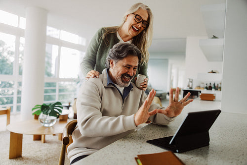 Senior couple make a video call on a tablet at home