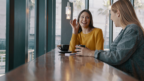 Two women friends chatting at a coffee shop