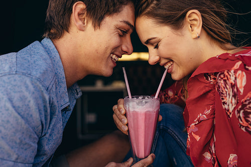 Romantic couple sharing a milkshake