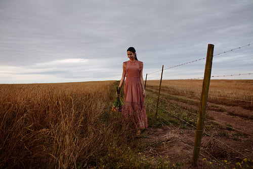 Woman walking in a field with flowers