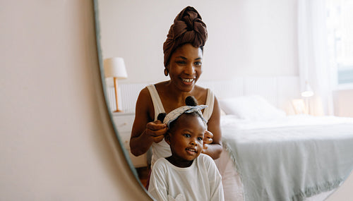 Mother styling daughter’s hair