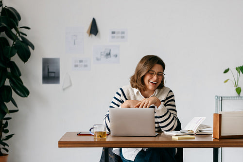 Home office life with a woman working at her desk and smiling