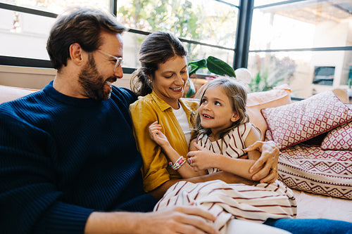 Family gathers on sofa, sharing smiles and warmth