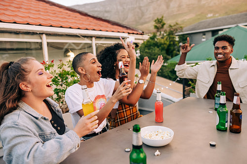 Friends cheering happily while having beers