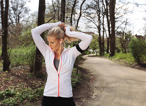 Fit young woman preparing for her run in forest